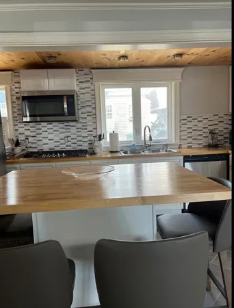 a kitchen with a sink and chairs