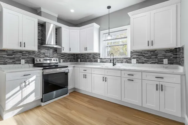 a kitchen with granite countertop white cabinets white stainless steel appliances and sink