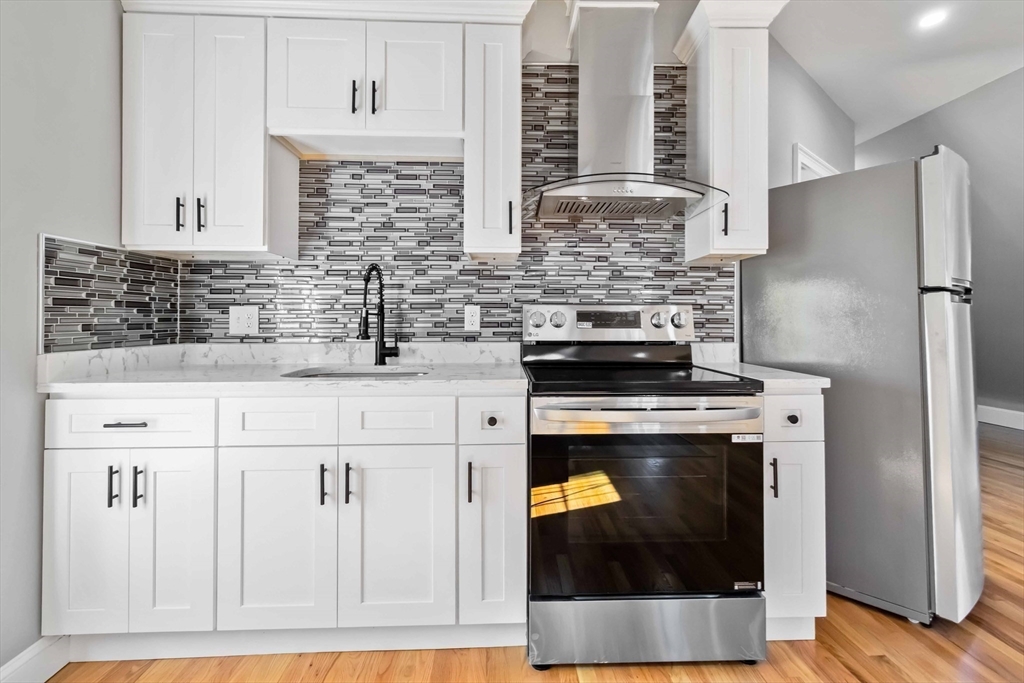 51 Mansfield Street, Unit 49 Everett, MA 02149 - Photo 22 of 31 a kitchen with stainless steel appliances granite countertop a stove and a refrigerator