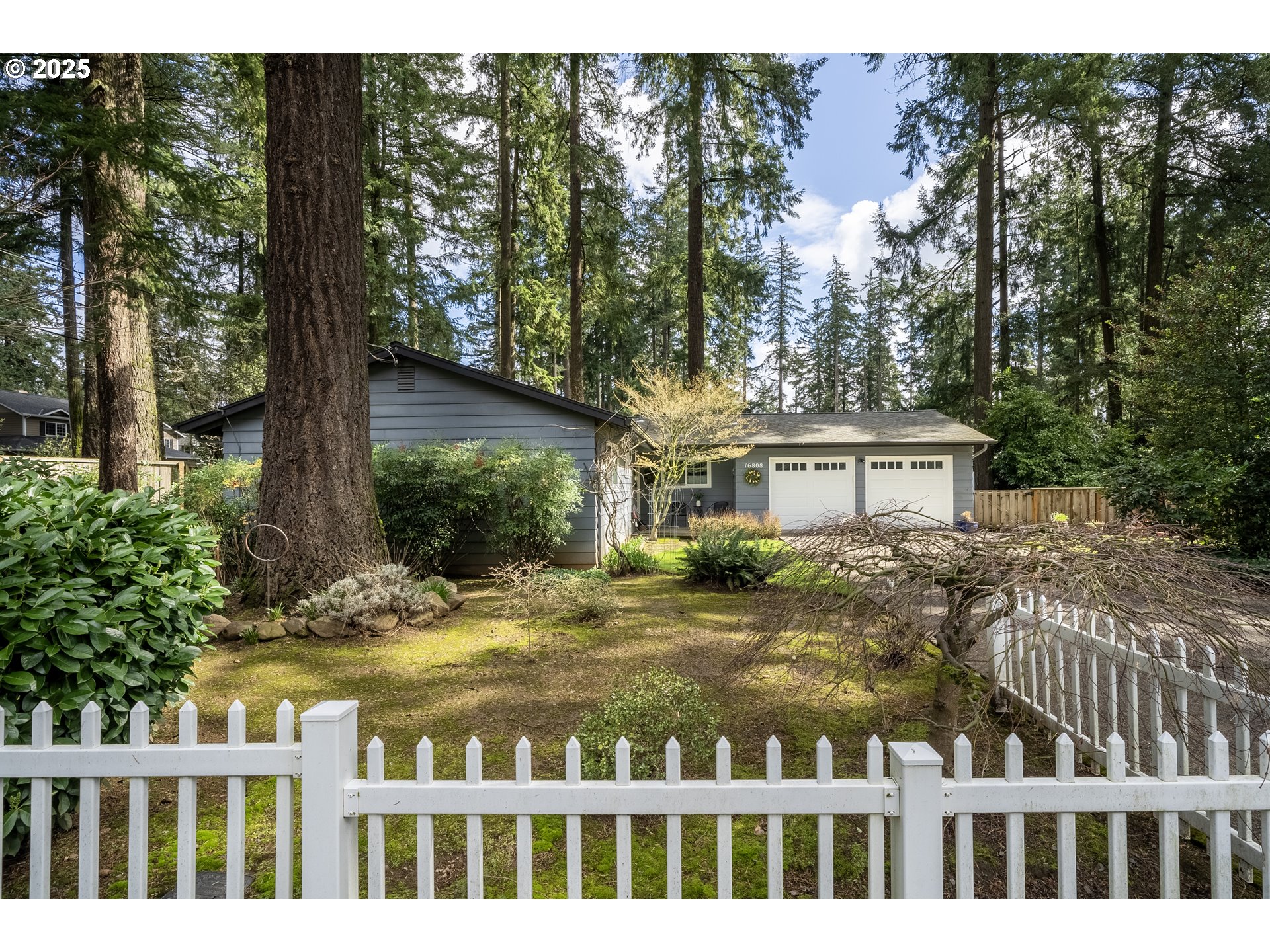 16808 Southwest Inverurie Road Lake Oswego, OR 97035 - Photo 2 of 38 a front view of a house with a garden