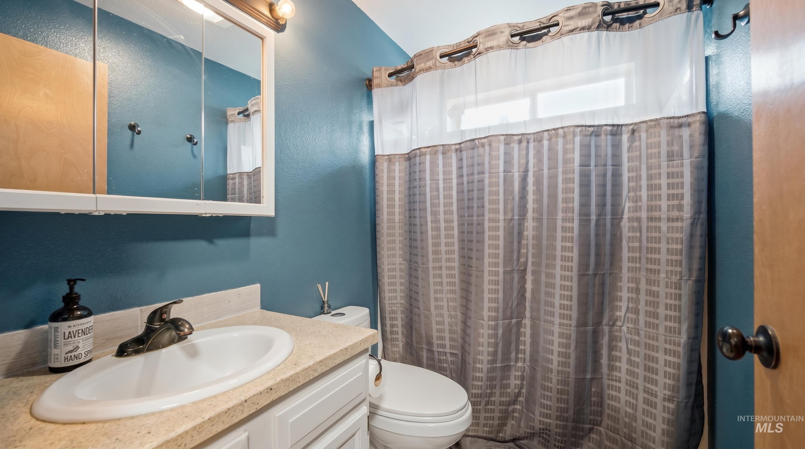 3980 North Pine-Featherville Road Mountain Home, ID 83647 - Photo 18 of 35 Bathroom featuring a single vanity with a laminate countertop and white cabinetry