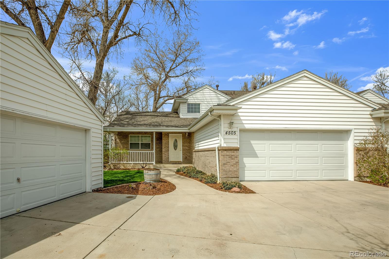 4505 Simms Court Wheat Ridge, CO 80033 - Photo 5 of 37 a front view of a house with a yard and garage