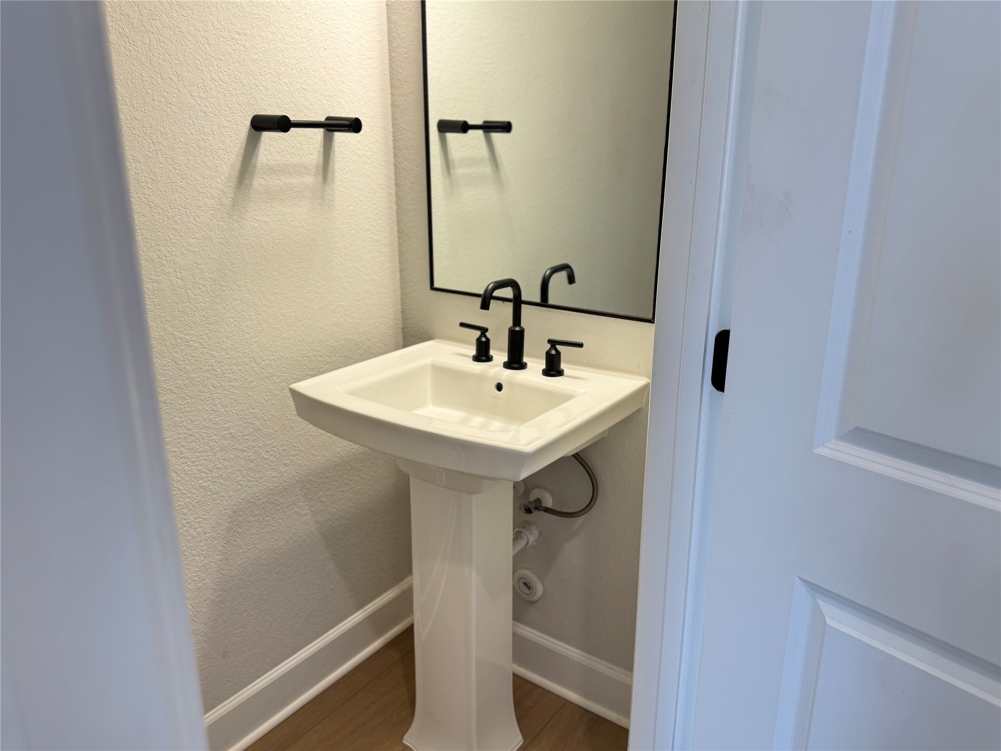 3000 Chisholm Trail Road, Unit 63 Round Rock, TX 78681 - Photo 10 of 31 Bathroom with a textured wall, baseboards, a sink, and wood finished floors