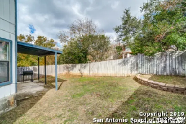 a backyard of a house with table and chairs