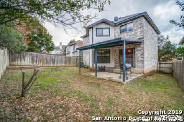 a view of a house with backyard and a tree