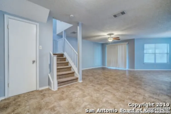 a view of an empty room with stairs and ventilation