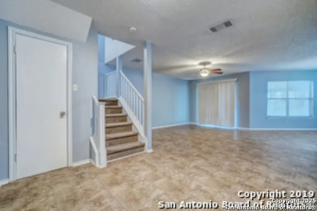 a view of an empty room with stairs and ventilation
