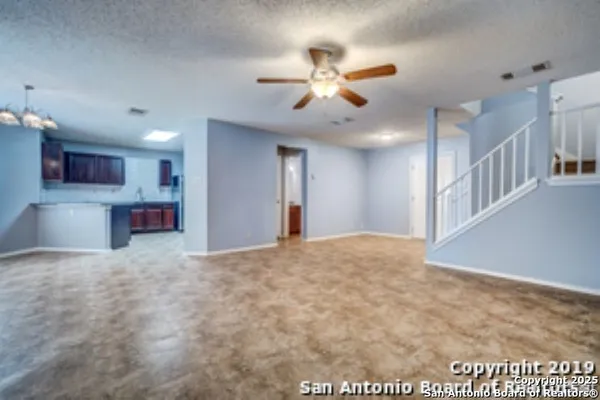 a view of an empty room and kitchen view
