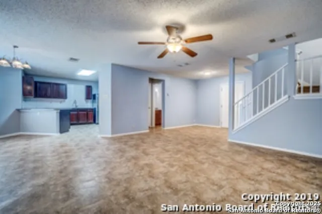 a view of an empty room and kitchen view