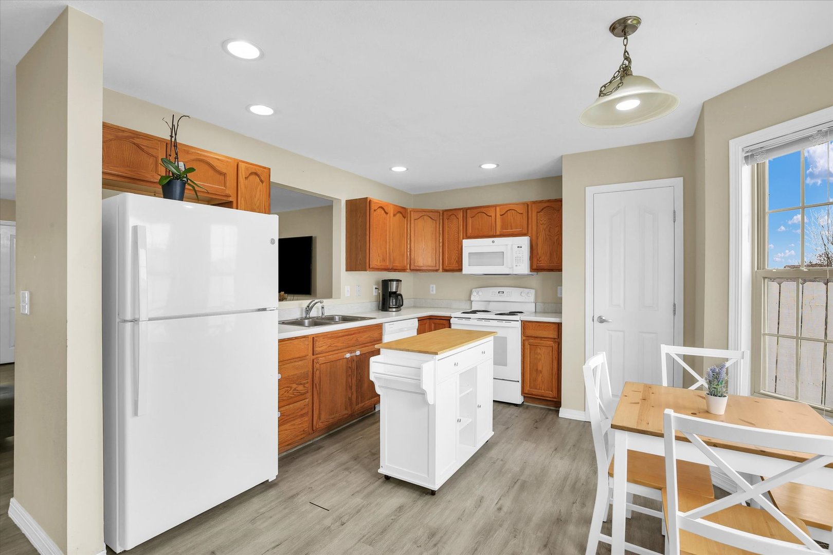 3715 Boulder Ridge Drive Champaign, IL 61822 - Photo 12 of 29 a kitchen with a refrigerator a stove top oven a sink dishwasher and white cabinets with wooden floor