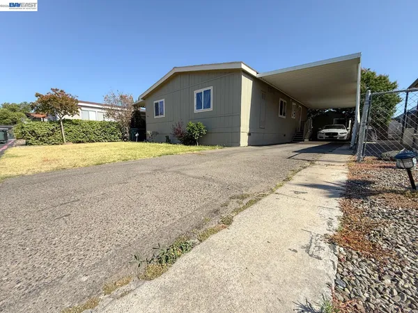 a view of a house with backyard and trees
