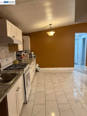 a kitchen with a stove cabinets and a sink