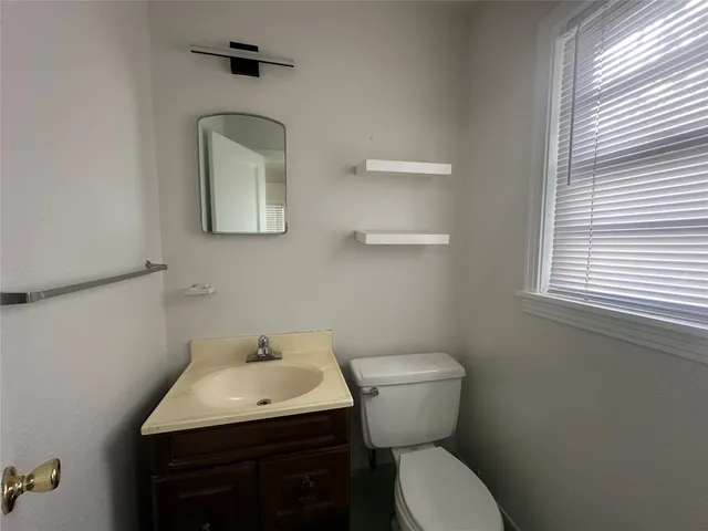 a bathroom with a toilet sink and mirror