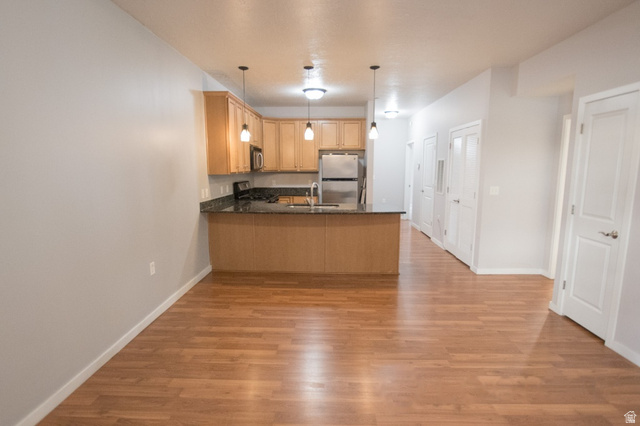 2150 South Main Street, Unit R405 Salt Lake City, UT 84115 - Photo 7 of 20 Open-concept living space with wood-finish flooring extending into the kitchen