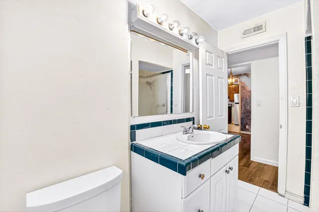 a bathroom with a tub shower sink and vanity