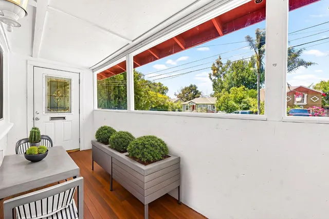 a front view of a house with wooden floor and a potted plant