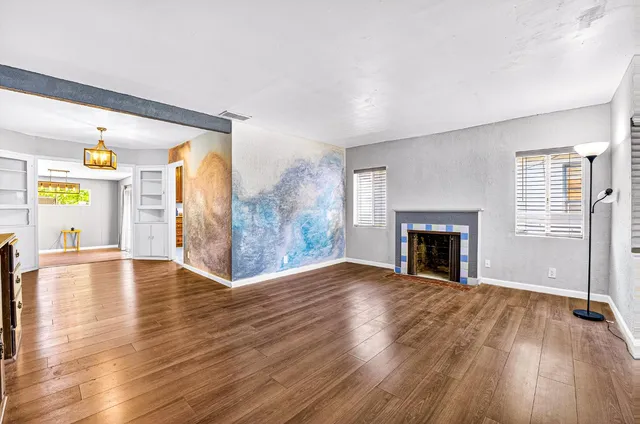 a view of empty room with wooden floor and fireplace