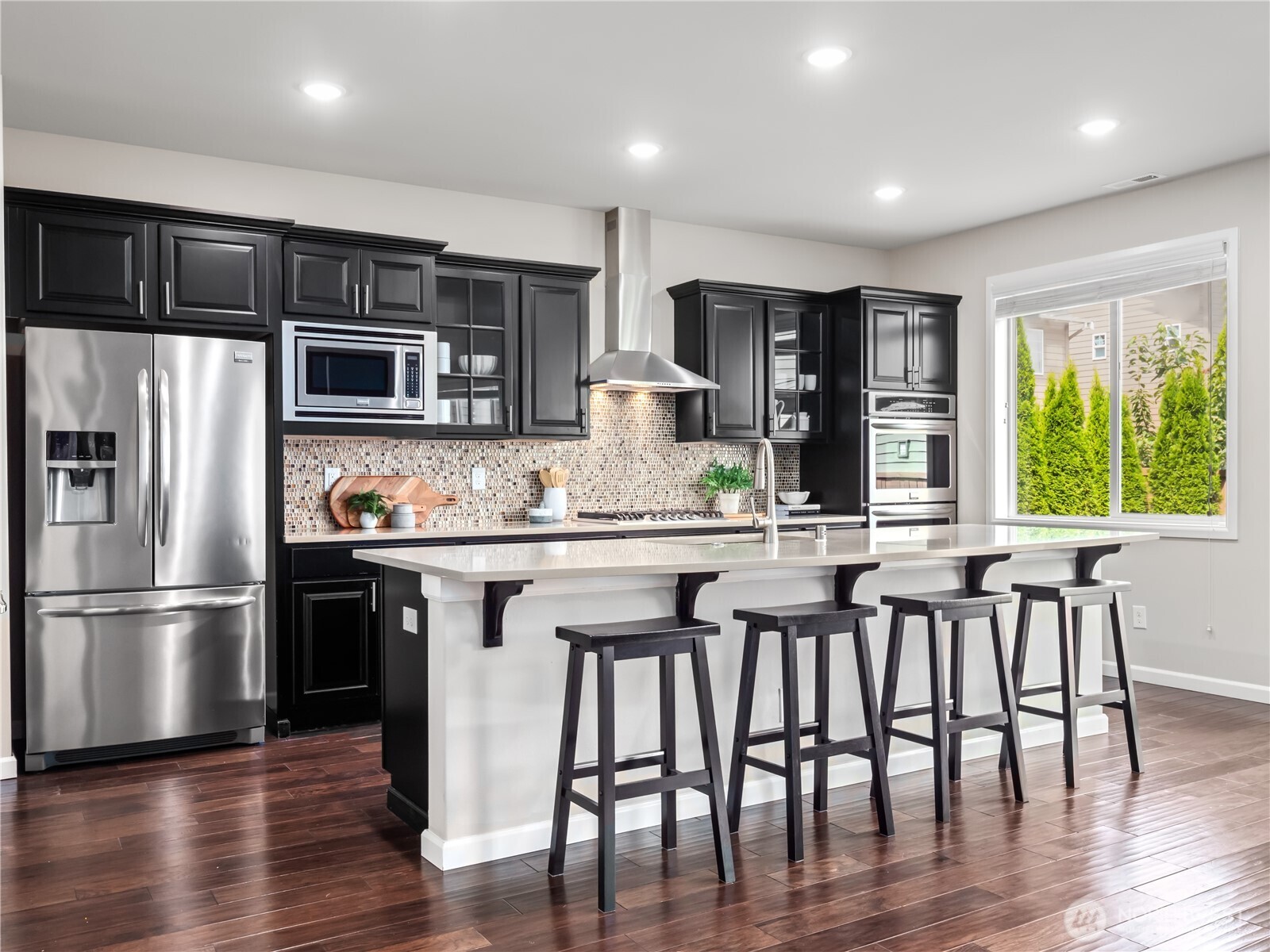3923 186th Place Southeast Bothell, WA 98012 - Photo 11 of 40 a kitchen with stainless steel appliances granite countertop a kitchen island hardwood floor and a large window