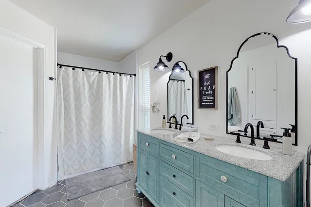 a bathroom with a double vanity sink and a mirror