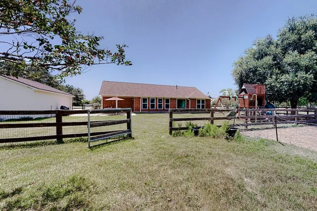 a backyard of a house with barbeque oven table and chairs