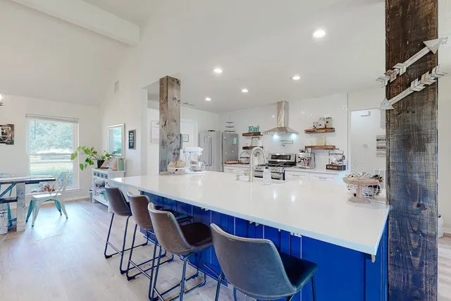 a kitchen with a dining table chairs and refrigerator