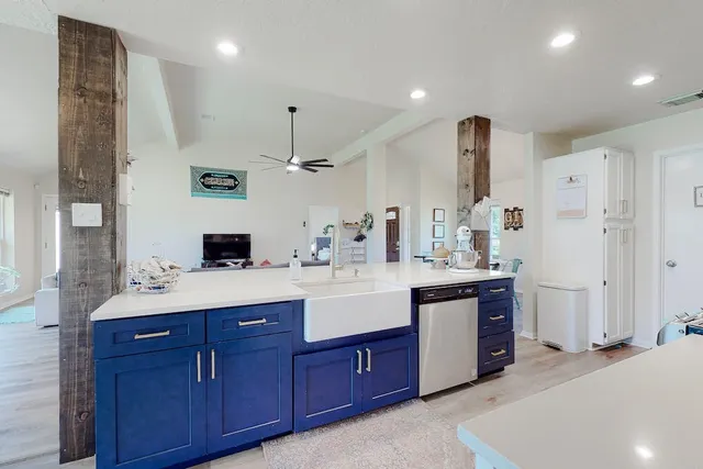 a spacious kitchen with stainless steel appliances a sink and a refrigerator