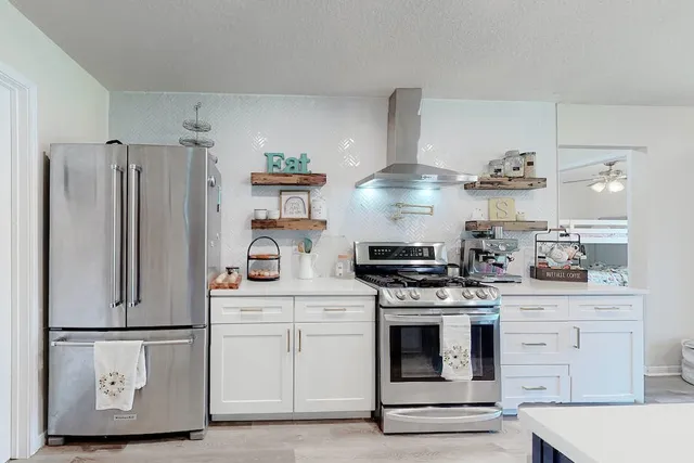 a kitchen with white cabinets and white appliances