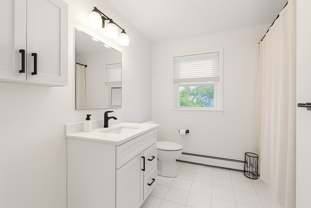 73 Spur Road Dover, NH 03820 - Photo 9 of 26 a bathroom with a toilet sink and mirror