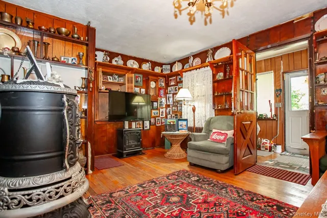 a living room with furniture a flat screen tv and a floor to ceiling window