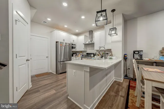 a kitchen with refrigerator cabinets and wooden floor