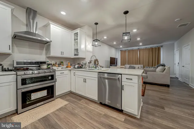 a kitchen with stainless steel appliances kitchen island granite countertop a stove a sink and a refrigerator