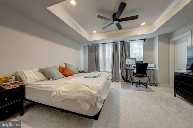 a bedroom with a bed a couch and a chandelier