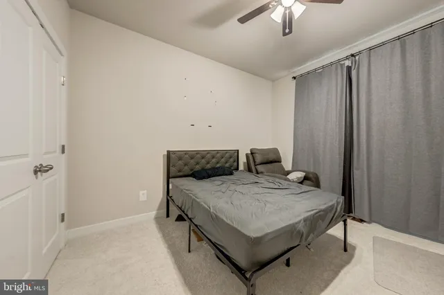 a bedroom with a bed and a chandelier fan
