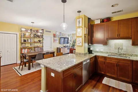 a kitchen with granite countertop kitchen island stainless steel appliances a sink stove and cabinets