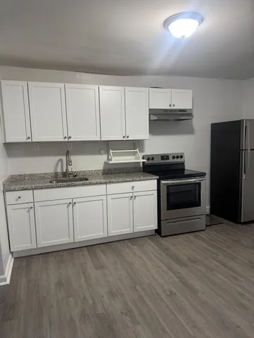 a kitchen with stainless steel appliances granite countertop a stove a sink and a refrigerator