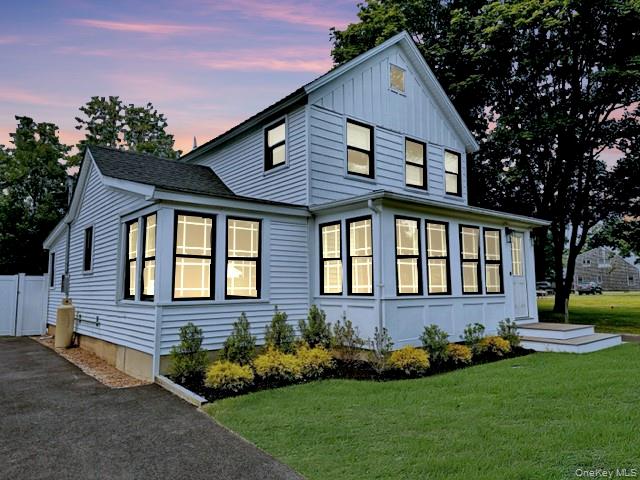 275 Sound Road Greenport, NY 11944 - Photo 1 of 33 View of front facade featuring driveway, a front yard, and board and batten siding