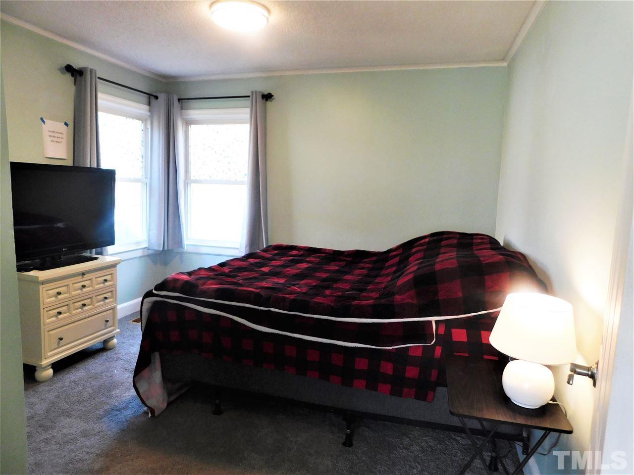 3033 Ross Road Durham, NC 27703 - Photo 17 of 30 a bedroom with a bed and flat screen tv