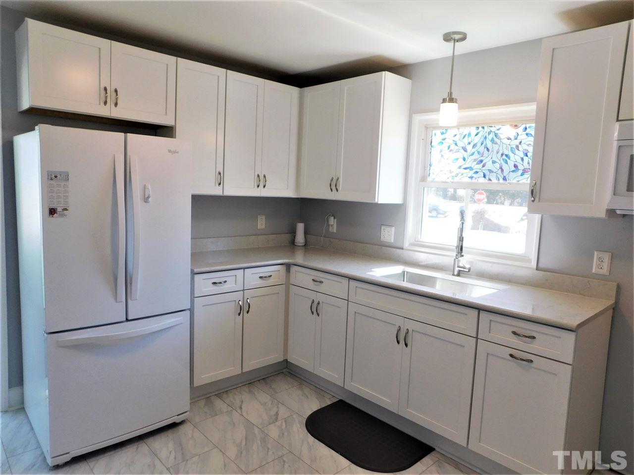 3033 Ross Road Durham, NC 27703 - Photo 6 of 30 a kitchen with granite countertop cabinets appliances a sink and a window