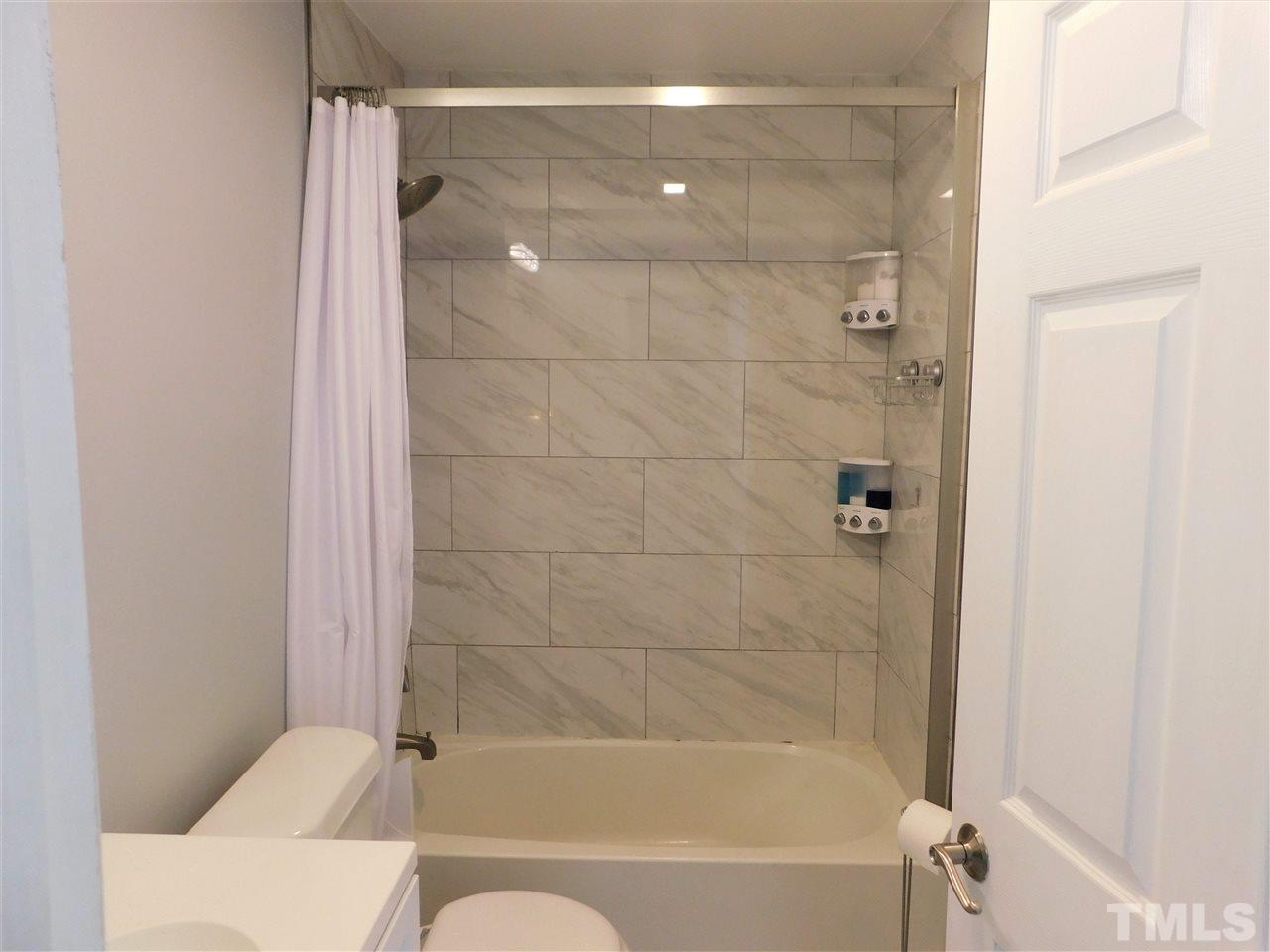 3033 Ross Road Durham, NC 27703 - Photo 9 of 30 a bathroom with a bathtub and a shower