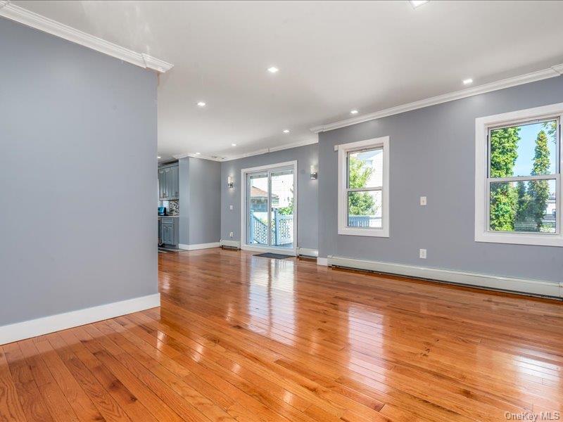 176-27 Sunbury Road Queens, NY 11434 - Photo 11 of 31 Unfurnished living room with crown molding, light wood-type flooring, recessed lighting, and a baseboard heating unit