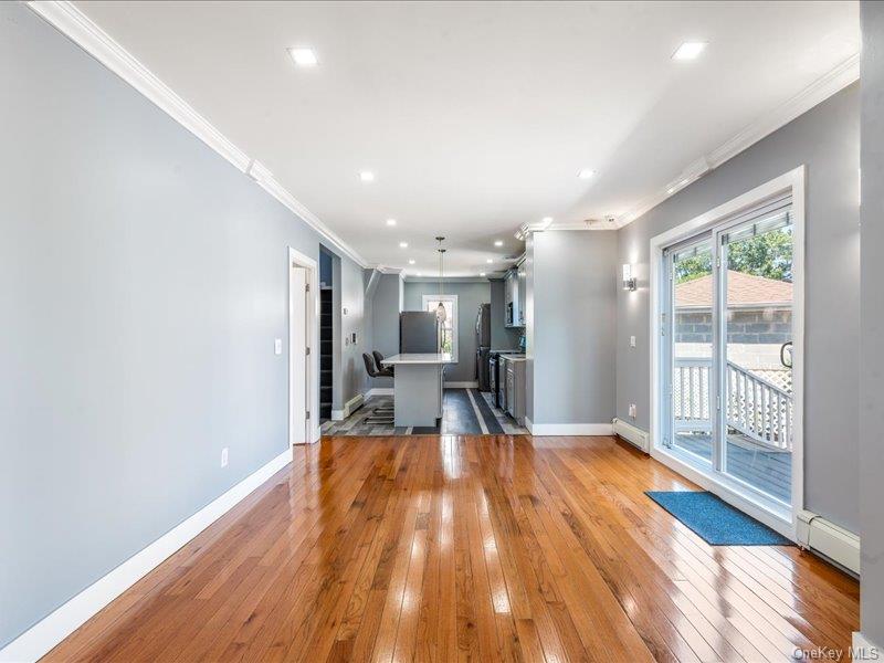 176-27 Sunbury Road Queens, NY 11434 - Photo 13 of 31 Unfurnished living room with ornamental molding, light wood finished floors, recessed lighting, baseboard heating, and a baseboard radiator