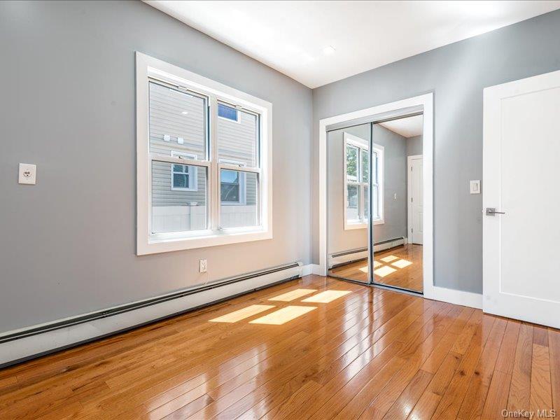 176-27 Sunbury Road Queens, NY 11434 - Photo 20 of 31 Unfurnished bedroom with baseboard heating, light wood finished floors, and a closet