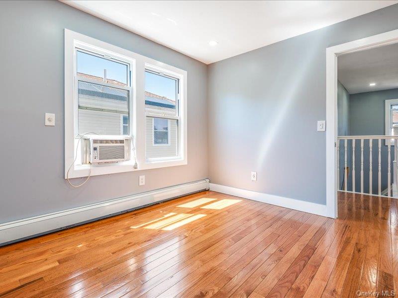 176-27 Sunbury Road Queens, NY 11434 - Photo 25 of 31 Unfurnished room with a baseboard radiator, light wood-type flooring, and cooling unit