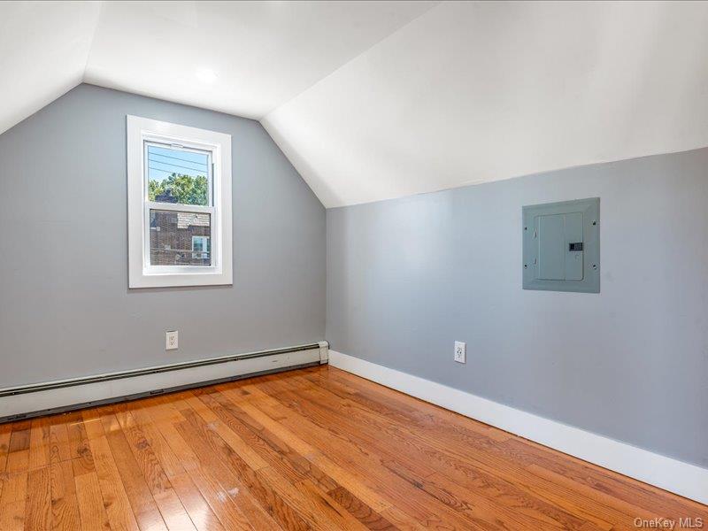 176-27 Sunbury Road Queens, NY 11434 - Photo 28 of 31 Bonus room featuring hardwood / wood-style floors, baseboard heating, electric panel, and vaulted ceiling