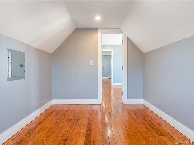 176-27 Sunbury Road Queens, NY 11434 - Photo 29 of 31 Additional living space with vaulted ceiling, light wood-type flooring, and electric panel