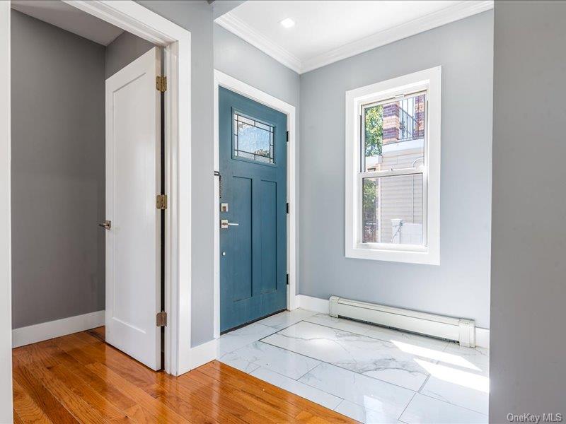 176-27 Sunbury Road Queens, NY 11434 - Photo 10 of 31 Foyer entrance featuring a baseboard radiator, crown molding, and marble finish floors