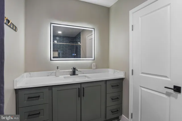 a bathroom with a granite countertop sink and a mirror