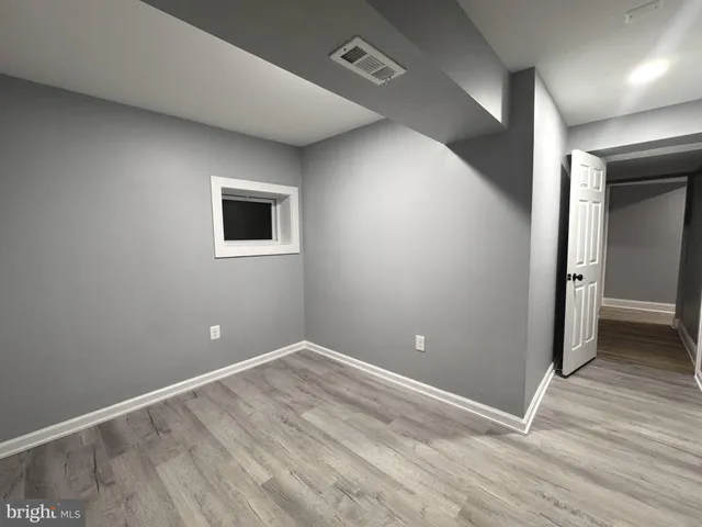 an empty room with wooden floor and closet