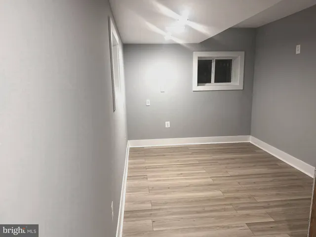 a view of a room with wooden floor and a window