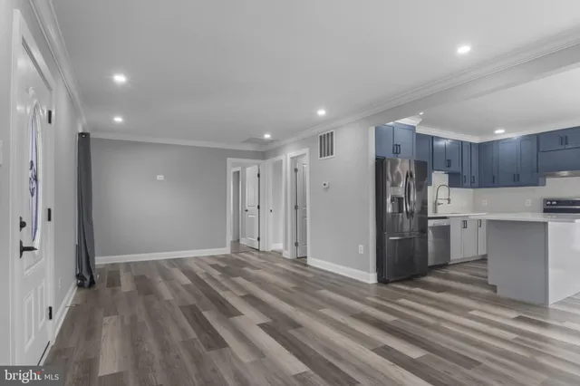 a view of kitchen appliances wooden floor and cabinets